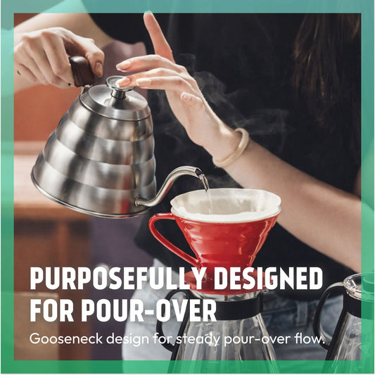Pouring hot water from a gooseneck kettle into a red pour-over coffee dripper