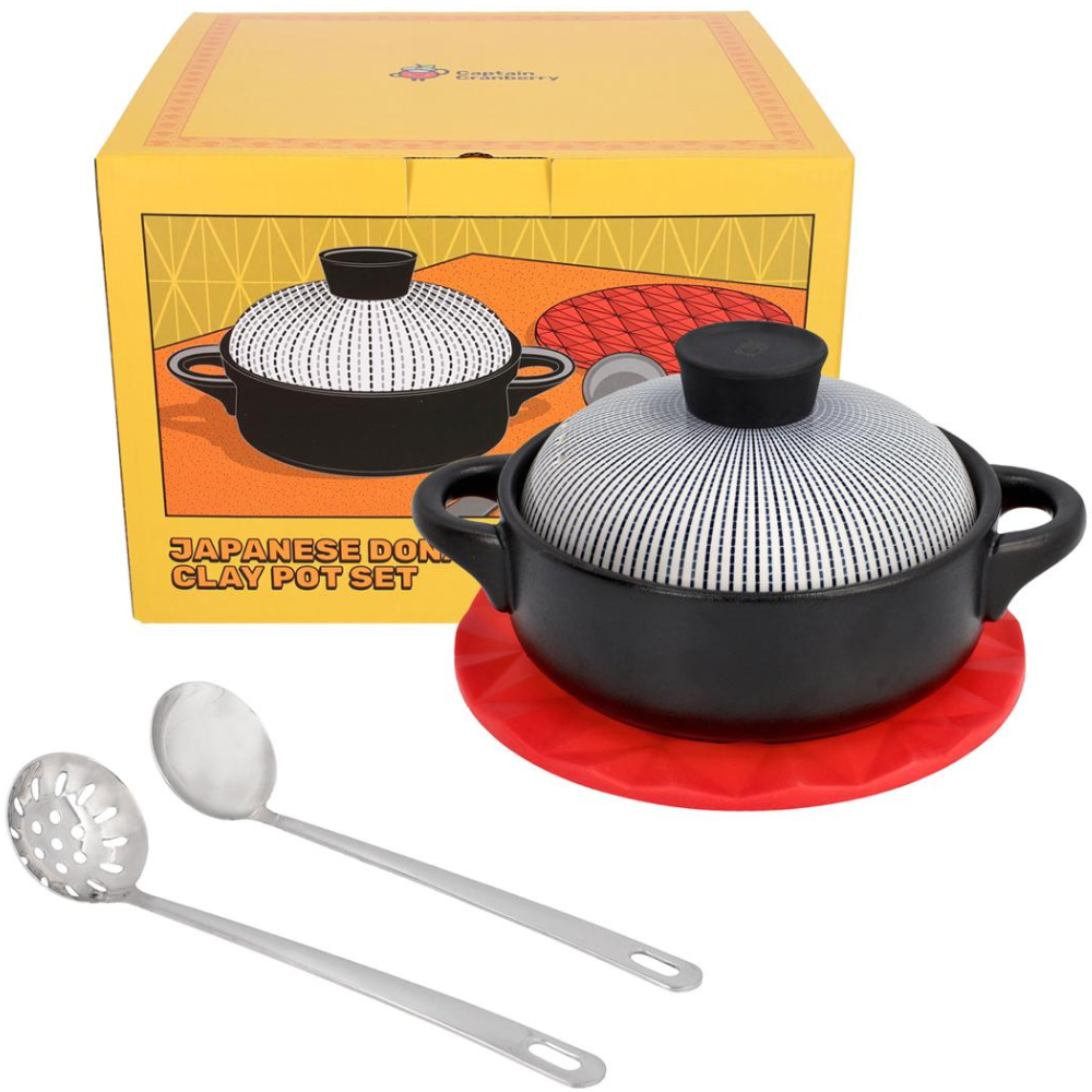 Japanese donabe clay pot set with a box, spoon, and red mat on a white background